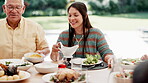 Family, thanksgiving or grandpa with a happy woman or food at table outdoor for celebration or tradition. Happy, smile or lunch with lady, salad or senior man eating meal together in social gathering