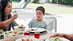 Family, thanksgiving dish and mother with son at table outdoor for celebration or tradition. Love, food or lunch with woman parent and boy child eating vegetables together at social gathering