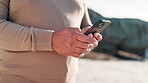 Senior hands, smartphone and technology on beach for connection, message and peace on summer vacation. Mature person, cellphone and retirement on travel adventure on social media and post of sea trip