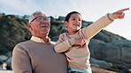 Child, bonding and grandfather by ocean with love, talking and happy to play on summer vacation. Old man, smile and care together for pointing, travel adventure and sunset leisure by beach on holiday