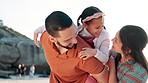 Beach, parents and girl on shoulders of father for adventure, playing or bonding together. Happy, sunset and child or kid with young mom and dad by ocean on tropical vacation, holiday or weekend trip