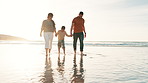 Beach, walking and boy holding hands with parents for adventure, fun or bonding together. Happy, sunset and child or kid with young mom and dad by ocean on tropical vacation, holiday or weekend trip