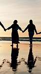 Back, holding hands and silhouette of family on beach, walking together for travel, holiday or vacation. Children, parents and grandparents by ocean or sea for love, adventure or bonding at sunset