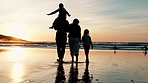 Back, piggyback and silhouette of family on beach, walking together for travel, holiday or vacation. Children, mother and father by water, ocean or sea for love, adventure or bonding at sunset