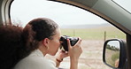 Woman, car and camera for photography in countryside, landscape or field for press job on road trip. Girl, person or photographer with photoshoot, nature magazine or creativity in vehicle on journey