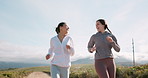 Fitness, friends and running, women on path in nature for outdoor workout in health and wellness. Sports, smile and happy people training for marathon together with commitment, talking and exercise.