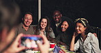 Happy people, friends and photography at night for dining, event or outdoor get together on bench. Group smile in diversity for photograph, picture or memory by dinner table in late evening outside