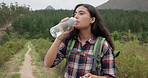 Hiking woman, drinking water and bottle on adventure for hydration, detox or wellness in nature. Girl, bush trekking and liquid for health in forest, woods or outdoor for fitness, training or summer