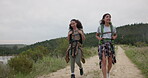 Friends, women walk and talk while hiking in nature, travel together for bonding and fun. Adventure, journey and trekking, sightseeing in forest or park for tourism, environment and backpacking