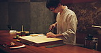 Sushi, fish and chef at restaurant cooking on table at diner or cuisine with ingredients at night. Kitchen, knife and culinary artist preparing a gourmet Japanese food, meal or snack at catering job.