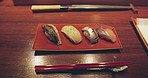 Closeup, sushi and plate in restaurant, chopsticks and food for cuisine, presentation and catering with meal. Fish, menu or diner for wellness ready and service for nutrition, diet and snack in Tokyo