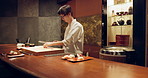 Sushi, food and chef at restaurant cooking on table at diner or cuisine with ingredients at night. Kitchen, fish and culinary artist preparing gourmet Japanese meal or snack with fish at catering job