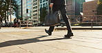 Legs, bag and business person walking, worker travel or commute to work in city with buildings. Corporate professional, sidewalk on urban street and journey to office with commuter in the morning