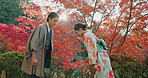 People in park in Japan, bow and traditional clothes with hello, nature and sunshine with respect and culture. Couple outdoor together in garden, greeting with modesty and tradition, polite and kind