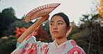 Fan, thinking or calm Asian woman in park for journey on holiday vacation for freedom or wellness. Nature, travel or Japanese person with ideas for health, peace and inspiration to relax in forest