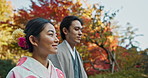 Asian couple, walking in garden and sunshine, peace and thinking about life, reflection and date in nature. Travel, people together in Japanese park for fresh air and calm with love, care and trust