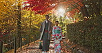 Japanese people in park, walking and traditional clothes with path, nature and sunshine with respect and culture. Couple outdoor together in garden, date or commitment with love, bonding and calm