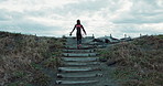 Back, woman and surfer at beach, walking up stairs and ready for fitness with wet suit, sports and surfing in nature. Steps, exercise and surfboard, ocean with professional or hobby with challenge