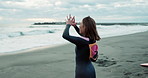 Surfer woman, stretching and training at beach, smile and ready for workout, exercise or wellness in morning. Person, happy and excited by ocean, waves and nature with health, back and arms in Japan