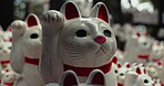 Calling cat, statue and outdoor shrine in nature, trees or forest for wish, faith or zoom in environment. Animal, toys and closeup for religion, worship or Buddhism with icon, symbol or wave in Japan