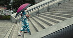 Japanese woman, umbrella and walk in kimono on stairs, city and wellness for heritage celebration. Young person, relax and traditional clothes in tokyo with beauty, steps and pride in japan fashion