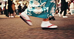 Japan, person and walk in shoes in kimono, city and travel for heritage in streets with people. Feet, slippers and traditional clothes in tokyo with adventure, culture and stroll in fashion in pride