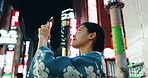 Cellphone, walking and Japanese woman in city for exploring, journey or adventure on holiday. Technology, sightseeing and young female person with picture photography on phone in street in Tokyo town