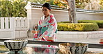 Shinto temple, woman and washing hands at fountain with container for cleaning, faith and worship. Religion, mindfulness and purification ritual to stop evil, bacteria and ladle at shrine in Tokyo