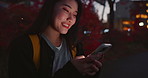 Happy asian woman, phone and night for social media, communication or outdoor networking in city. Female person relax on mobile smartphone in late evening for online chatting in urban town of Japan