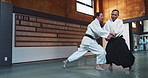 Aikido, fight and sensei master in martial arts with training of student in self defence or discipline. Class, demonstration and Japanese man with black belt in fighting for education of skill