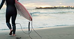 Legs, person and walking into ocean with surfboard at beach, ready for fitness in wet suit, sports and surf in nature. Energy, action and waves with surfer, professional or hobby with back view
