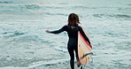 Back, woman and running into ocean with surfboard at beach, ready for fitness in wet suit, sports and surfing in nature. Energy, action and waves with surfer, professional or hobby for extreme sport