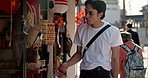 Walking, shopping and Japanese man in the city exploring on a summer vacation, adventure or holiday. Travel, sightseeing and young male person commuting in street in Yokohama town on weekend trip.