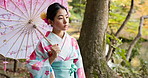 Walking, nature and traditional Japanese woman in indigenous clothing, style and kimono with umbrella. Culture, fashion and person in garden for fresh air, wellness and thinking outdoors by lake