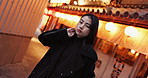 Japanese woman, outdoor and night in street with light, bokeh and face on walk, tourism or adventure in city. Person, portrait and adventure to explore town, holiday or vacation on sidewalk in Tokyo