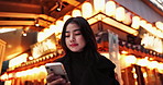 Japanese woman at temple, checking phone and typing online chat on late commute in city. Search, schedule and travel, Asian girl reading email or post on smartphone app on journey in Tokyo at night.