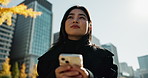 Japanese woman, smartphone and positive in city for work and travel wellness in outdoor environment. Young person, mobile and enjoy view in tokyo with technology, connected and sunshine in urban town