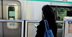 Japanese woman, smartphone and transport by train on station with scroll app and technology for communication. Person, cellphone and waiting for city travel in tokyo, metro and typing on social media