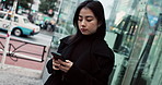 Japanese woman in city with phone, typing and reading online chat on morning commute. Search, schedule and travel, Asian girl on street checking email or post on smartphone app on journey in Tokyo.