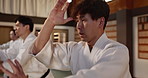 Students, fitness or learning martial arts in dojo for practice, aikido movement or self defense together. Combat demonstration, Japanese people or training workout for fighting, education or class