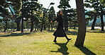 Asian, woman and freedom in park, happy with sunshine and energy for wellness, smile and walking outdoor. Trees, nature and smile, care free in public garden in Japan and positivity with fresh air