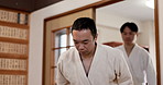 Martial arts students, bow or respect in dojo for aikido practice, discipline or self defense. Black belt, Japanese people learning combat or training workout for fighting class or group education