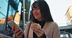 Happy asian woman, phone and laughing with muffin in city for funny joke, communication or social media. Female person smile on mobile smartphone while eating desert or cupcake in an urban town