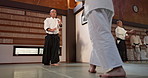 Group of students in dojo with sensei for aikido training, fitness and development in balance, exercise and gym. Teaching, learning and fighting, traditional Japanese martial arts class with aikidoka