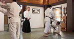 Students, aikido or Japanese sensei teaching martial arts in dojo for practice, body movement or self defense. Combat demonstration, group or people training workout for fighting, education or class
