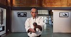 Fitness, sword or sensei martial arts in dojo for practice routine, aikido movement or self defense. Combat demonstration, mature Japanese person or training workout for fighting, education or class
