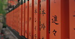 Japan, red pillar and writing for religion, shrine and Japanese tradition outdoor with travel and tower. Spiritual, ancient structure and architecture with history of Hanamikoji Street in Kyoto