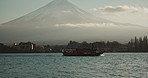 Mountain, landscape and travel with boat on sea with sky, nature and journey for holiday or vacation. Fujiyoshida, Japan and skyline of environment in summer with ship on ocean, water or river