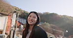 Japanese woman, walking and face in city, street and sunshine with vision, idea or smile on vacation. Girl, person and metro sidewalk by buildings, hill or holiday on adventure for journey in Tokyo