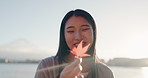 Japanese woman, maple leaf and lake for smile, thinking or memory in nature, adventure or holiday in sunrise. Girl, plant and happy for holiday by water, environment or outdoor with sunshine in Tokyo